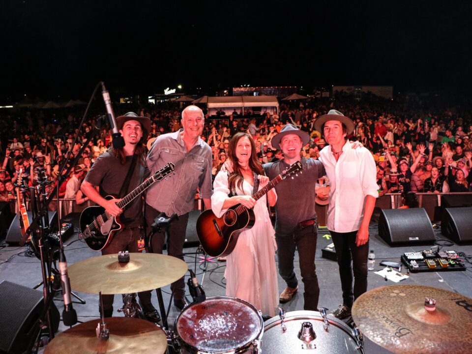 Band on stage with crowd cheering in the back