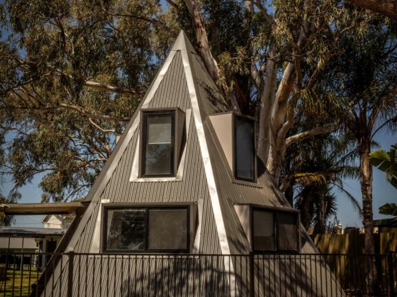 Triangular cabin surrounded by trees