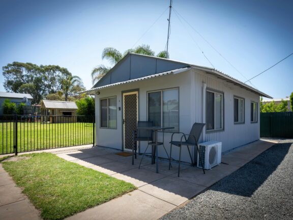 House with two chairs in the front and an AC unit