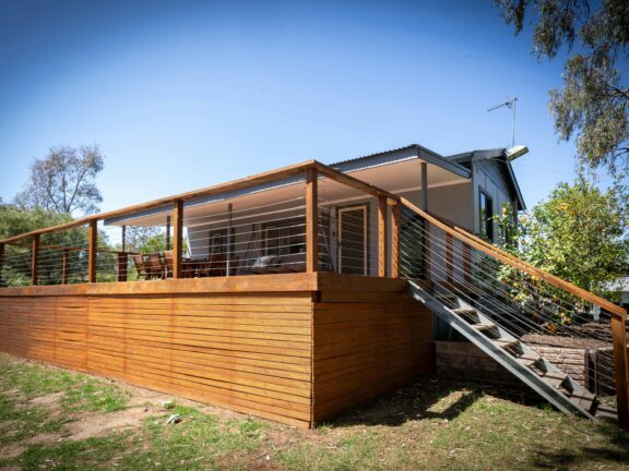 Front view of house with a deck and stairs