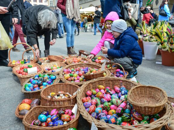 Kids going through a basket of Easter eggs in a market