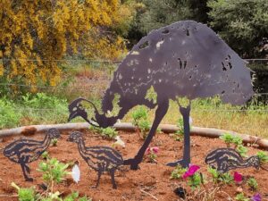 Laser cut metal decoration of an adult emu and 3 chick emus on soil