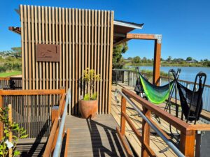 ramp to a balcony with two hammocks overlooking a river
