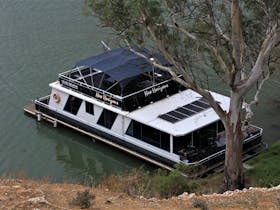 New Horizons houseboat docked on a river