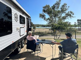 Elderly couple relaxing under the sun outside their caravan